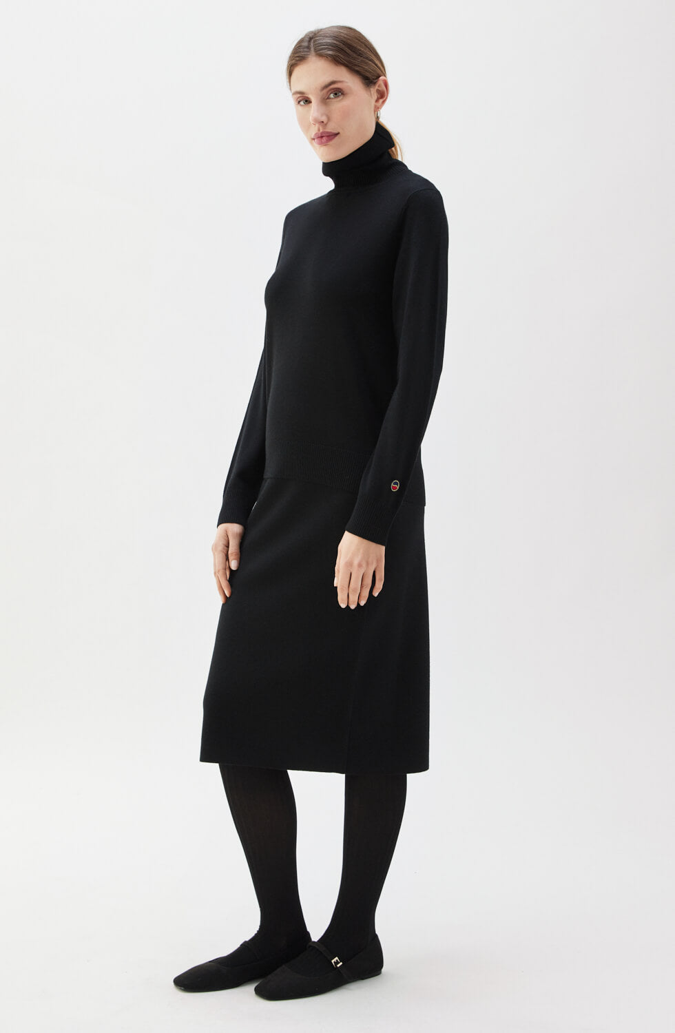 Woman wearing a black turtleneck dress on a white background